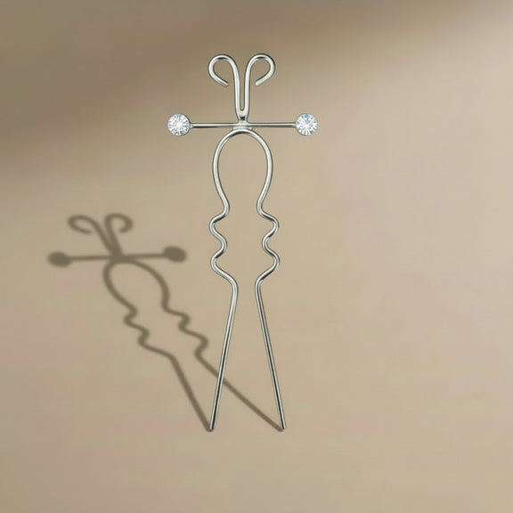 Silver hairpin with crystal elements on a beige background