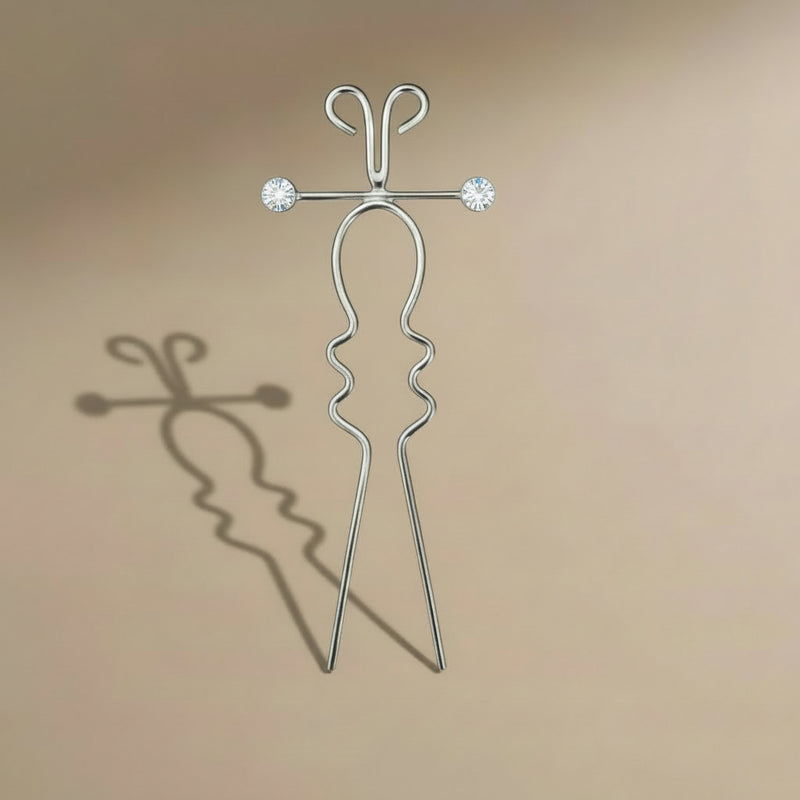 Silver hairpin with crystal elements on a beige background